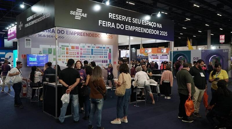 a foto mostra um estande do ano de 2024 com pessoas reunidas em volta do mesmo